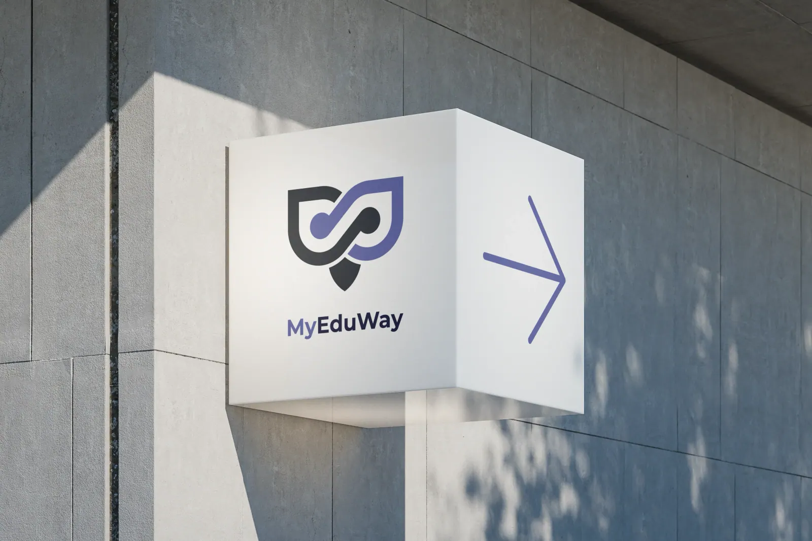 Szyld MyEduWay w formie sześcianu ze strzałką na betonowej elewacji